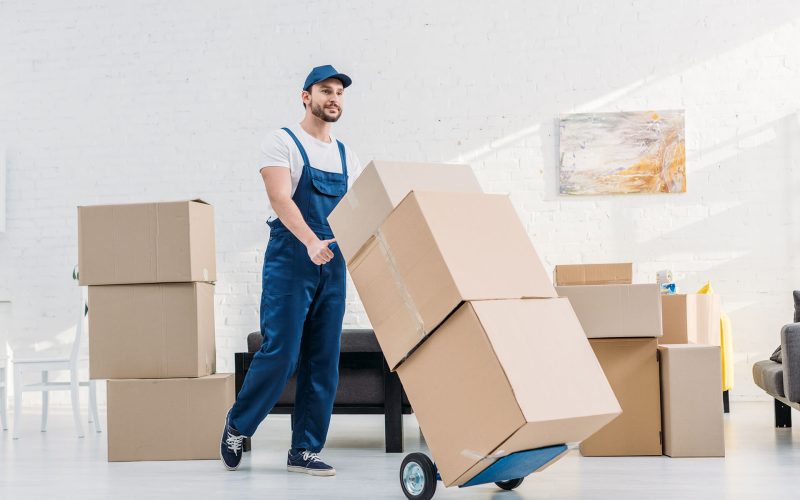 mover-in-uniform-transporting-cardboard-boxes-on-X6KAQDN.jpg